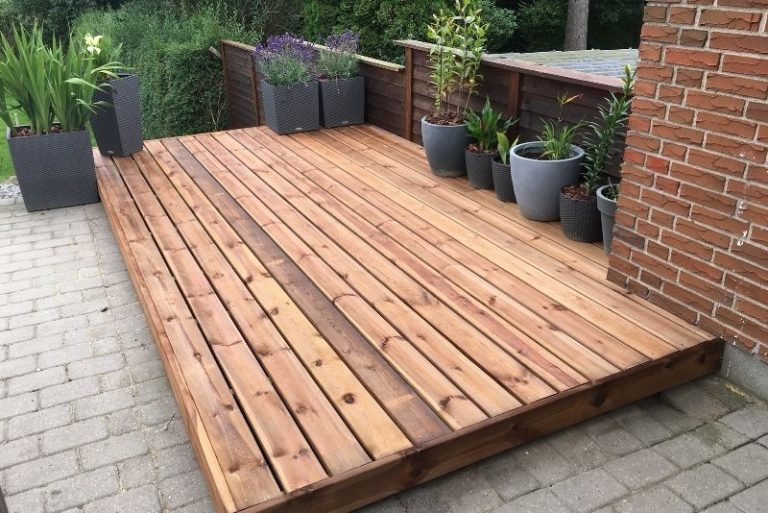 Newly stained timber deck with potted plants along the edge