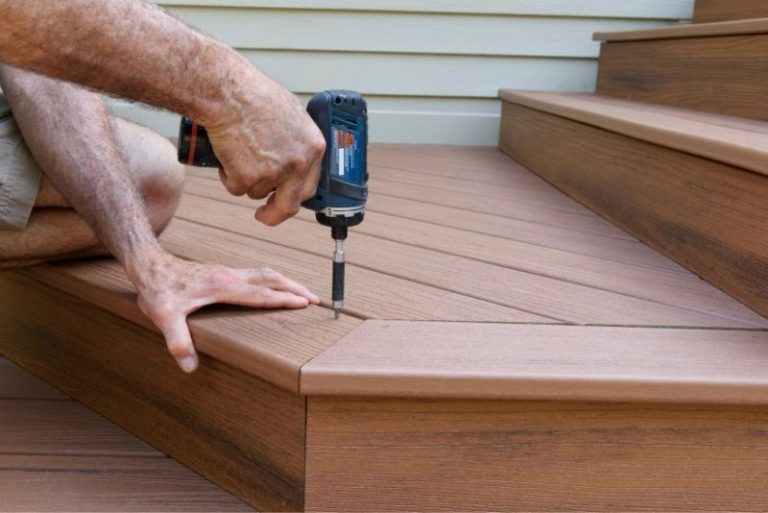 Close-up of hands screwing down composite decking boards on a deck step